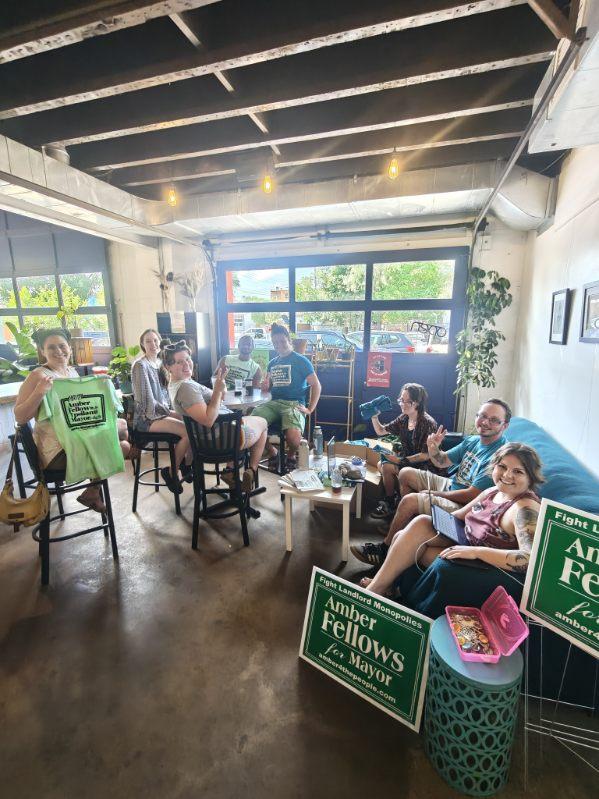 Amber Fellows and supporters organizing together in a cafe space with campaign signs and shirts.